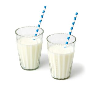 Mango lassi in a clear glass, creamy yogurt drink with a warm golden hue