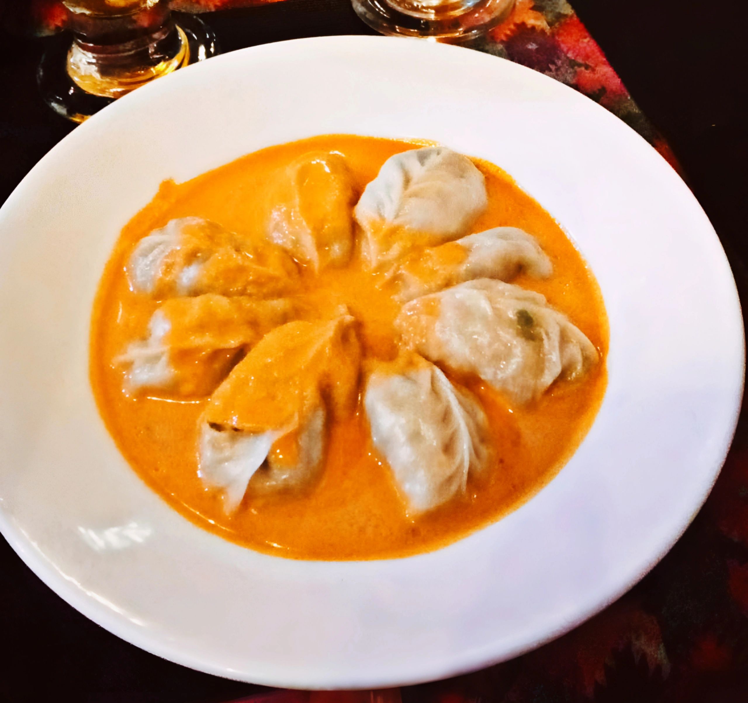 Jhol momo dumplings served in spicy tomato-sesame broth