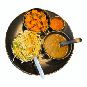 Classic Nepali thali-style combo platter (rice and curry sides) on a plate, overhead close-up