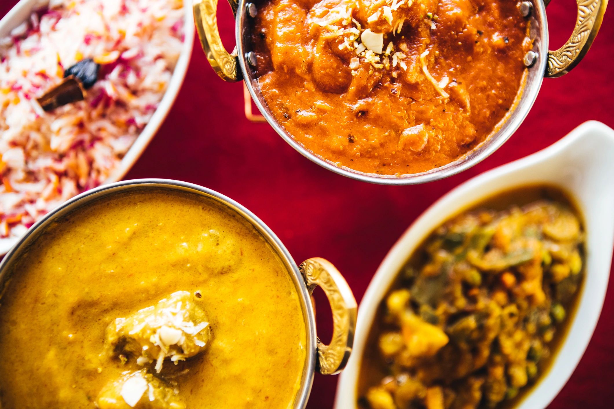 Assorted curry bowls with basmati rice on a table, close-up